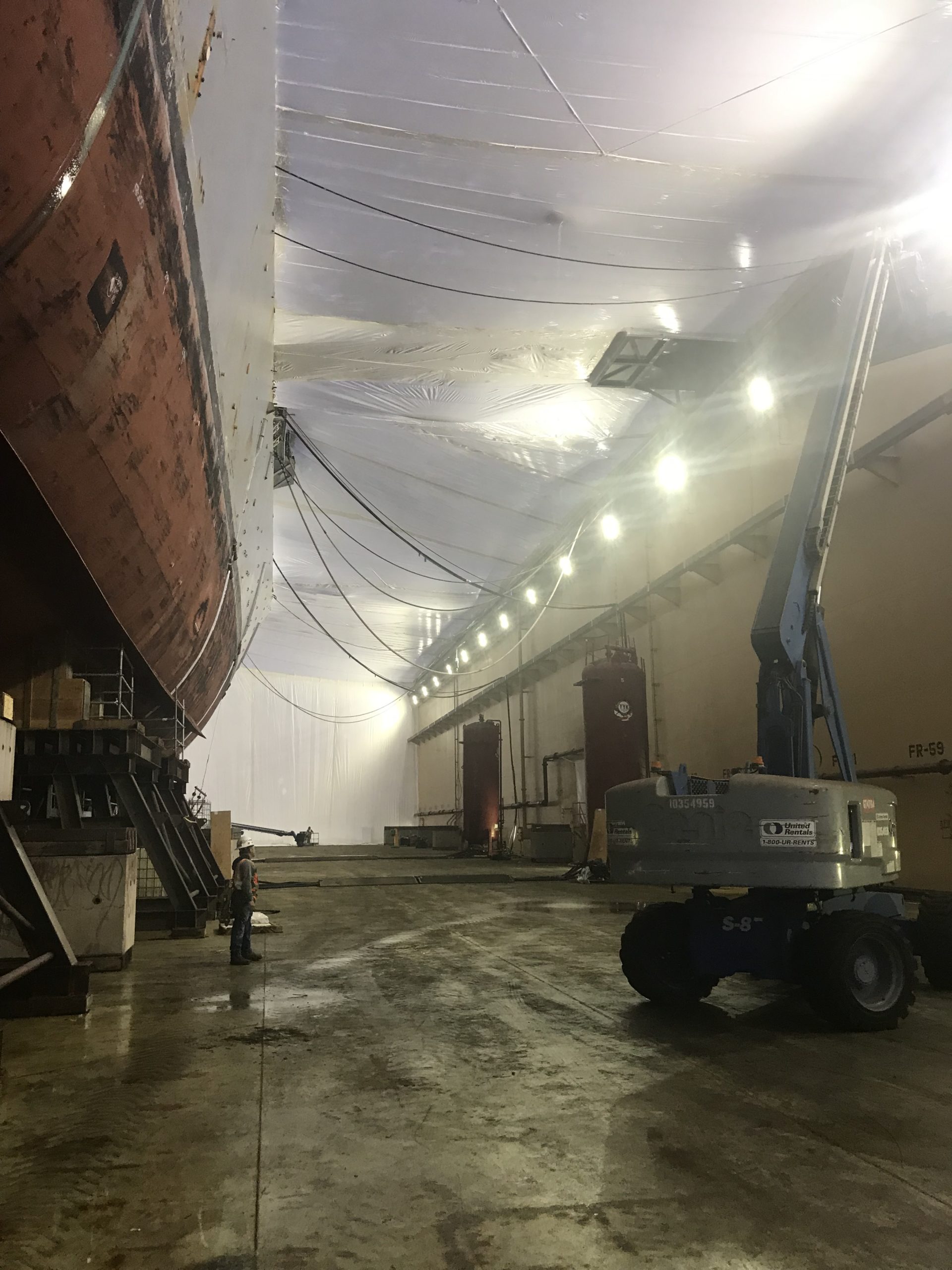 Premier Scaffold, Inc. is diligently working on a ship in their warehouse.