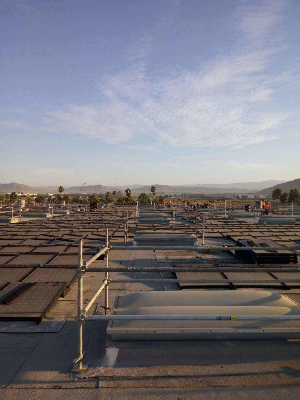The roof of a building with solar panels on it, showcased by Premier Scaffold Inc.