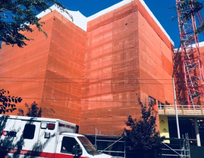 A Premier Scaffold, Inc. ambulance parked in front of an orange building.